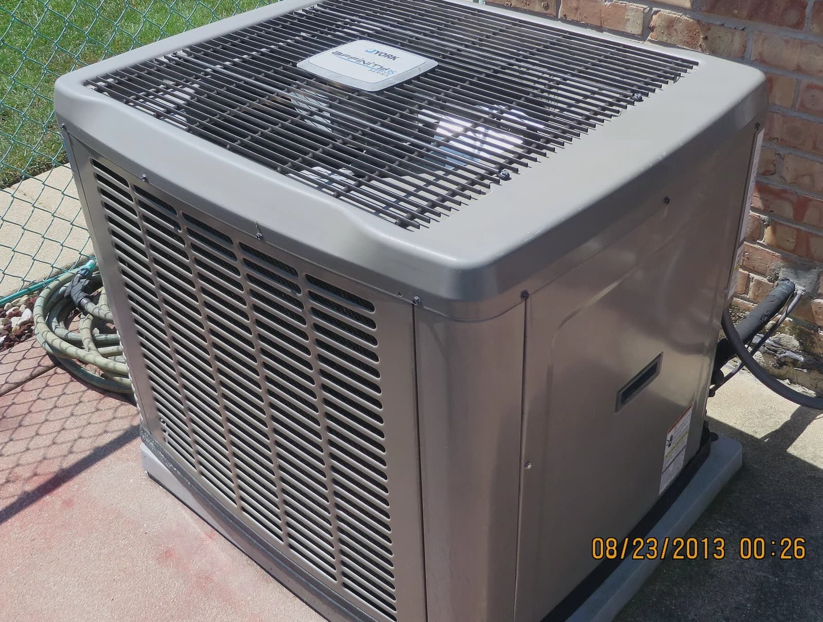 Residential air conditioning condenser unit outside a home, the kind Dallas HVAC companies service in summer