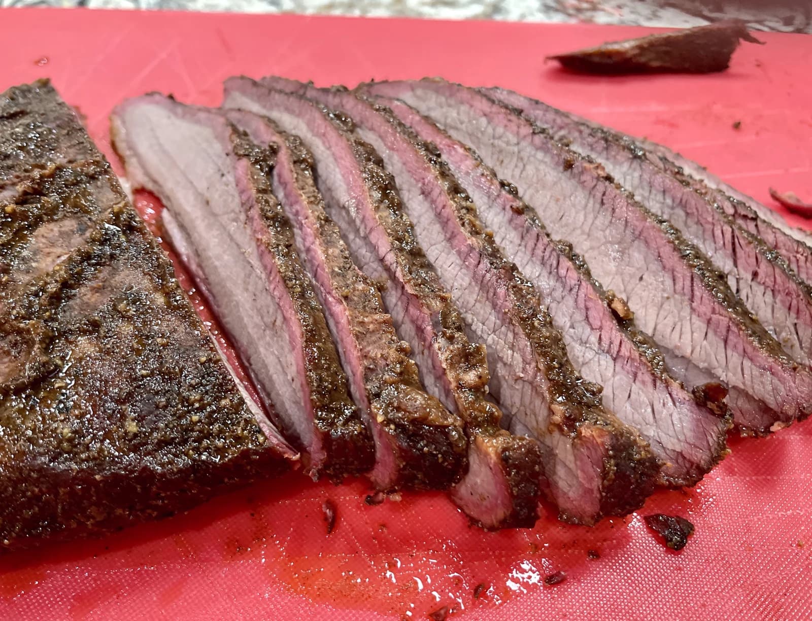Sliced smoked brisket with a deep smoke ring, the measure of the best Texas BBQ